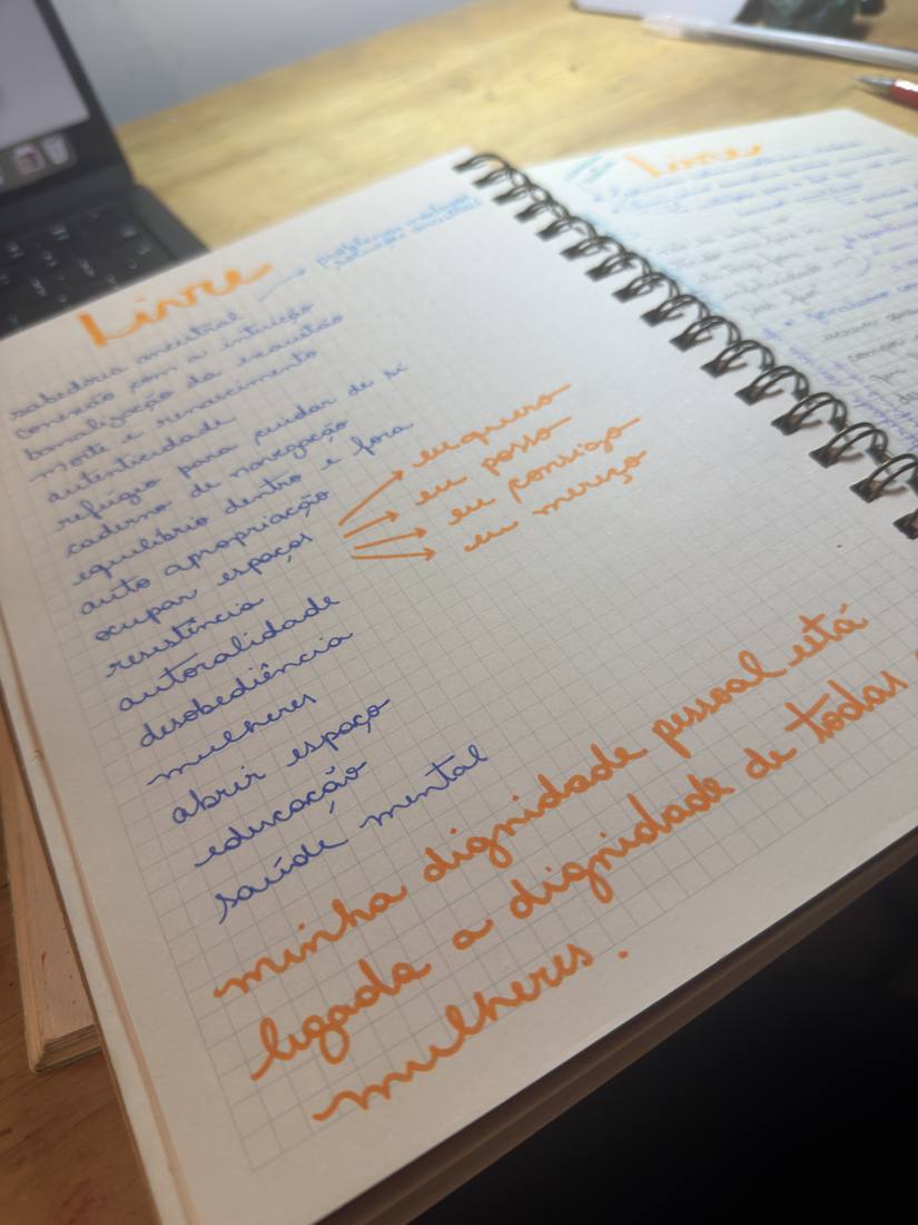 Caderno aberto sobre uma mesa, com anotações manuscritas